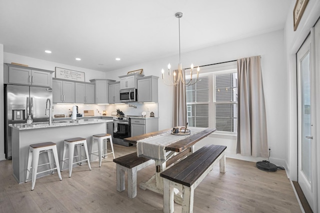 dining space featuring a wealth of natural light, light hardwood / wood-style floors, and a notable chandelier