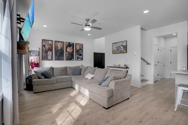 living room featuring ceiling fan and light wood-type flooring