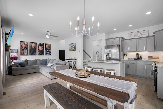 dining space with ceiling fan, sink, and light hardwood / wood-style floors