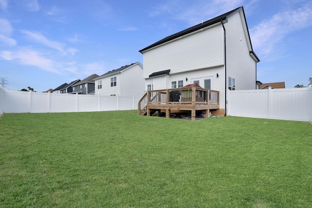 back of property featuring a deck and a lawn