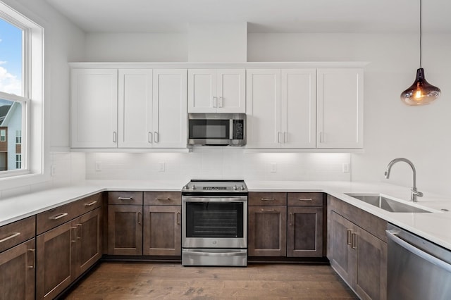 kitchen featuring pendant lighting, white cabinetry, appliances with stainless steel finishes, and sink