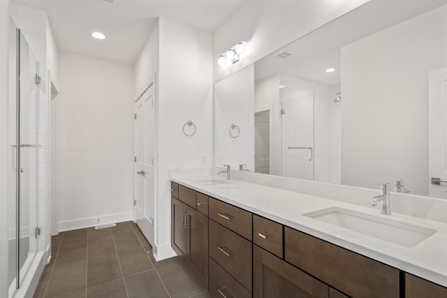 bathroom featuring vanity, a shower with shower door, and tile patterned flooring