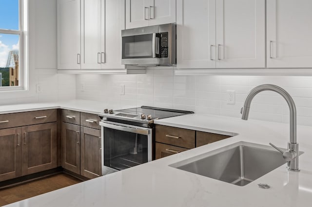 kitchen featuring stainless steel appliances, dark hardwood / wood-style flooring, sink, and decorative backsplash