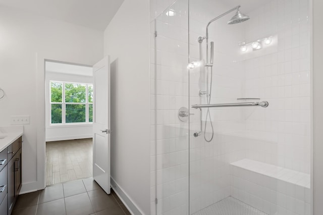 bathroom featuring vanity, tile patterned floors, and a tile shower