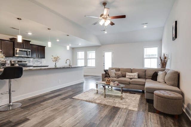 living room featuring dark wood-type flooring, ceiling fan, lofted ceiling, and sink