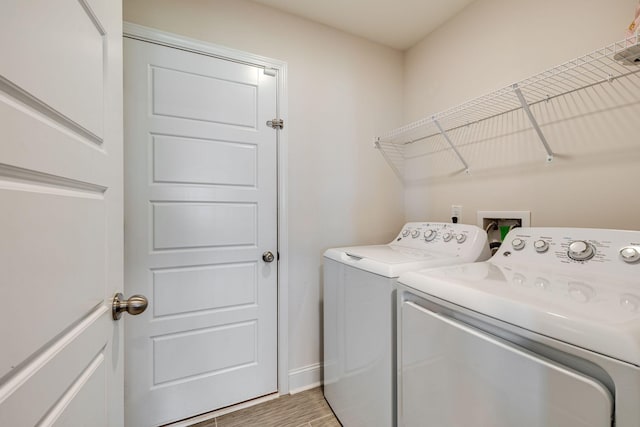 washroom featuring washing machine and clothes dryer and light hardwood / wood-style flooring