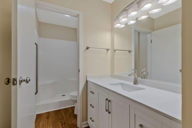 bathroom featuring walk in shower, vanity, toilet, and wood-type flooring