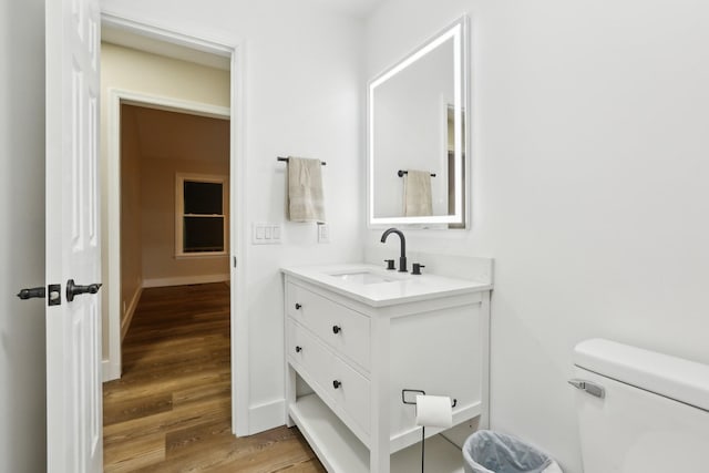 bathroom featuring wood-type flooring, toilet, and vanity