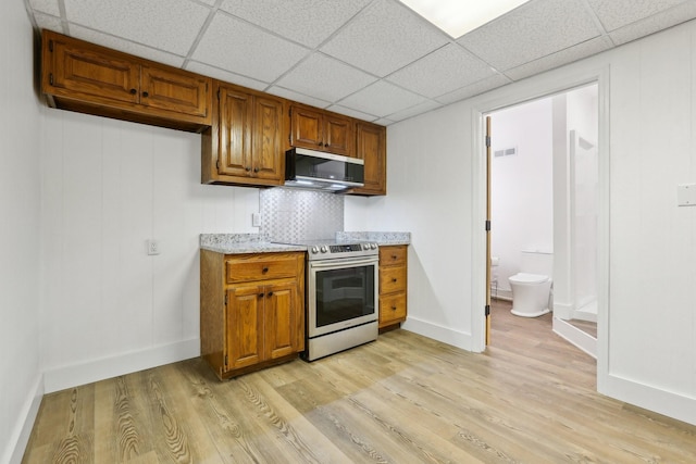 kitchen featuring tasteful backsplash, appliances with stainless steel finishes, a drop ceiling, and light hardwood / wood-style flooring