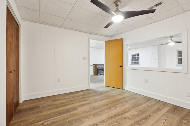 spare room featuring wood-type flooring, a paneled ceiling, and ceiling fan