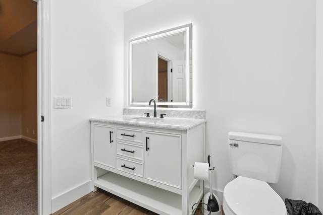 bathroom with vanity, toilet, and wood-type flooring