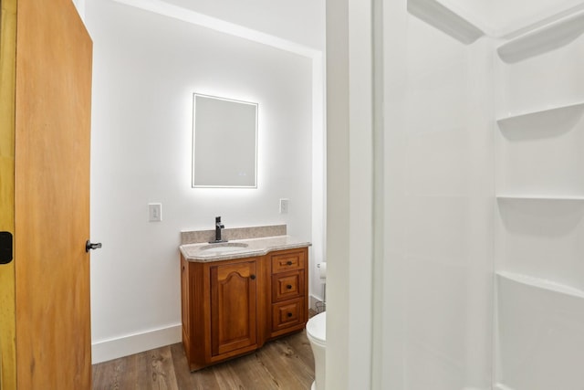 bathroom featuring wood-type flooring, toilet, and vanity