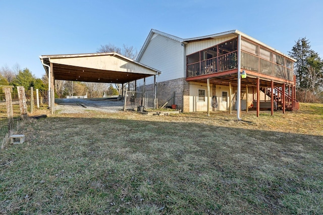 rear view of house featuring a sunroom and a yard