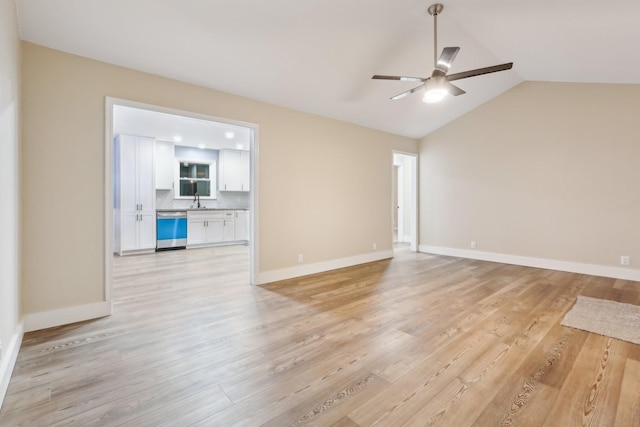 spare room featuring lofted ceiling, sink, light hardwood / wood-style floors, and ceiling fan