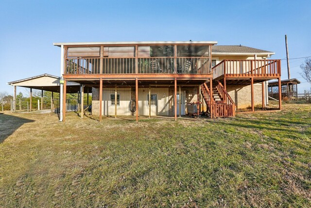 rear view of house with a wooden deck, a sunroom, and a yard