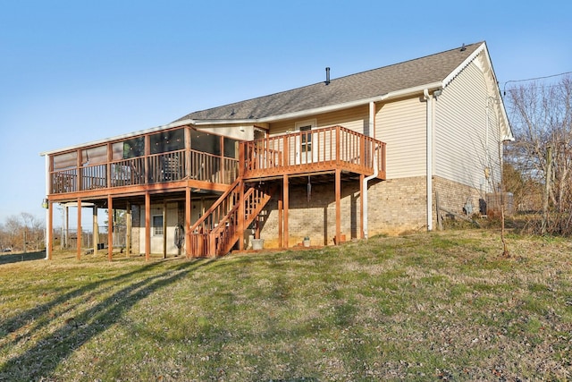 rear view of house with a wooden deck, a lawn, and a sunroom