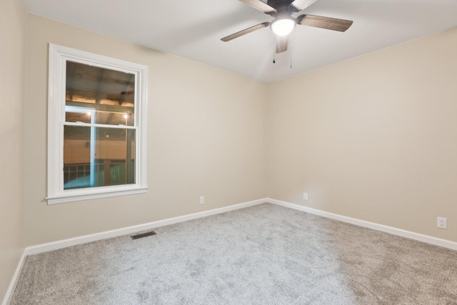 carpeted spare room featuring ceiling fan