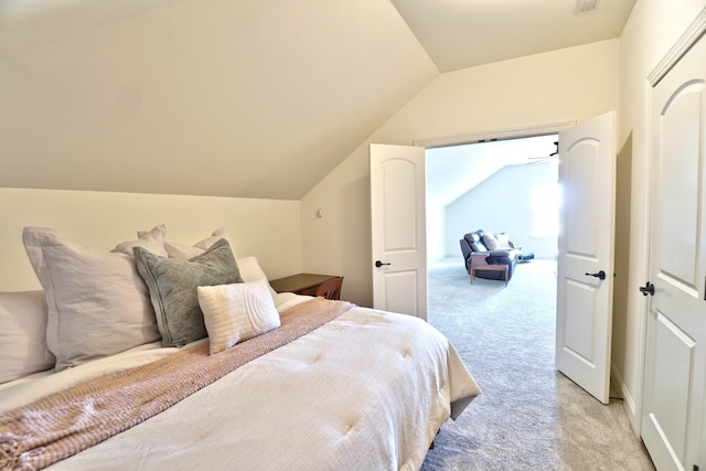 bedroom with lofted ceiling and light carpet