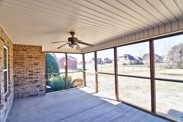 unfurnished sunroom with ceiling fan