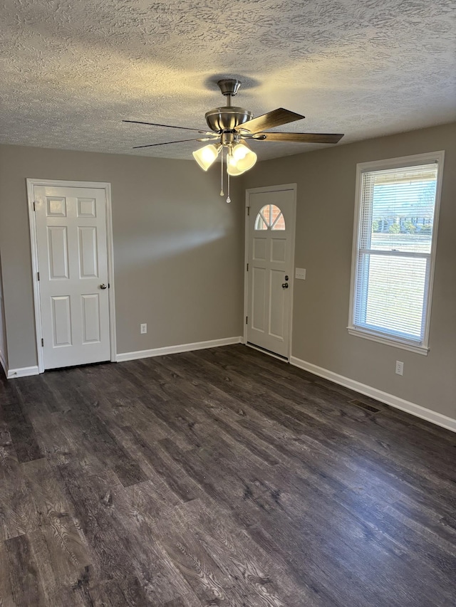 foyer with ceiling fan, dark hardwood / wood-style floors, and a textured ceiling