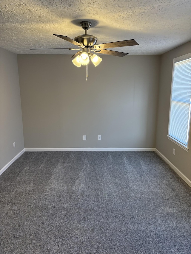 carpeted spare room featuring ceiling fan and a textured ceiling