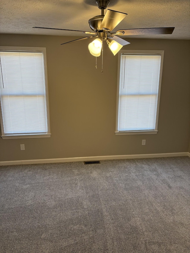 carpeted empty room with ceiling fan and a textured ceiling