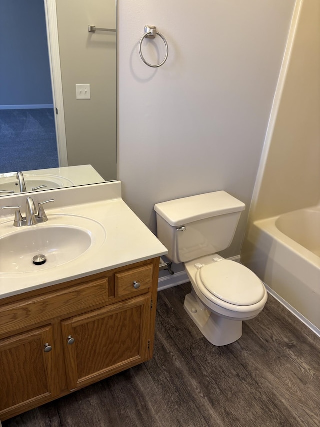 bathroom with hardwood / wood-style flooring, vanity, and toilet