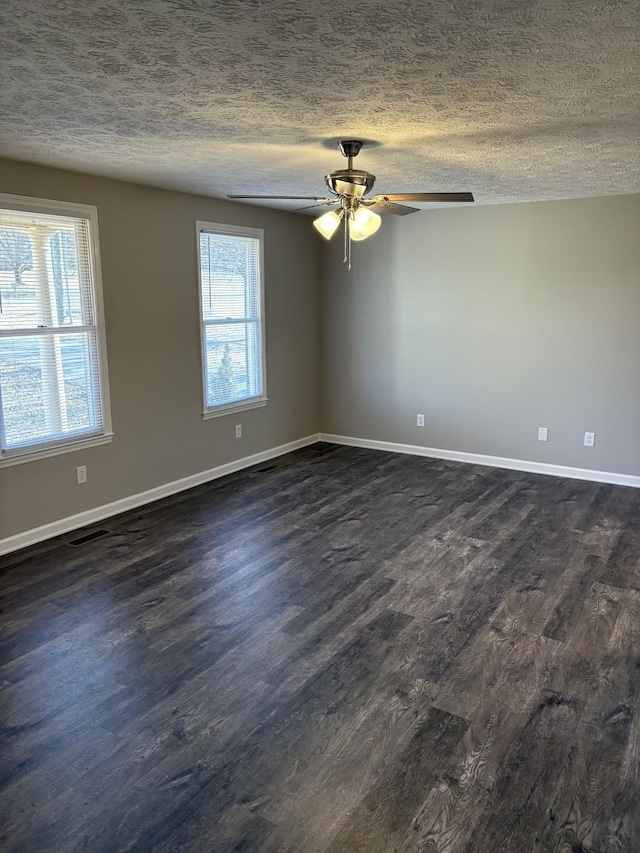 empty room with ceiling fan, dark hardwood / wood-style floors, and a textured ceiling