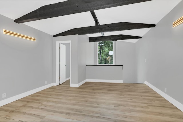 unfurnished room with lofted ceiling with beams and light hardwood / wood-style flooring