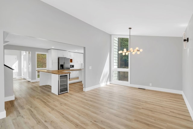 kitchen with wooden counters, white cabinetry, wine cooler, stainless steel fridge with ice dispenser, and decorative light fixtures