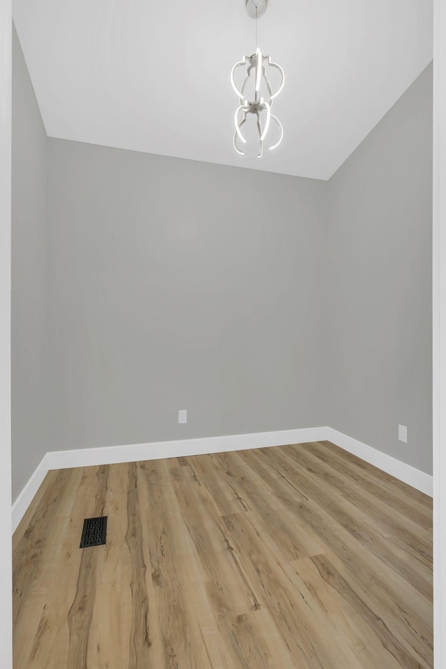 unfurnished dining area featuring light hardwood / wood-style flooring and a notable chandelier