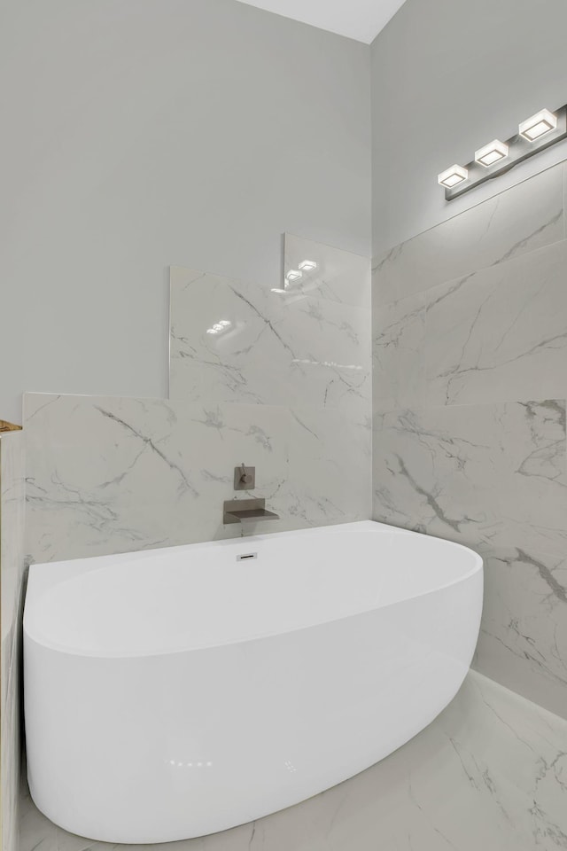 bathroom with tile walls and a bathtub