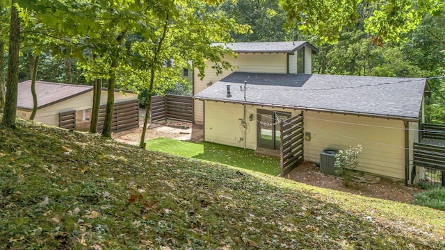 back of property featuring central AC and a lawn