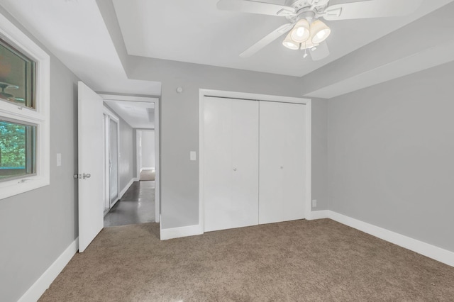 unfurnished bedroom featuring carpet, ceiling fan, and a closet