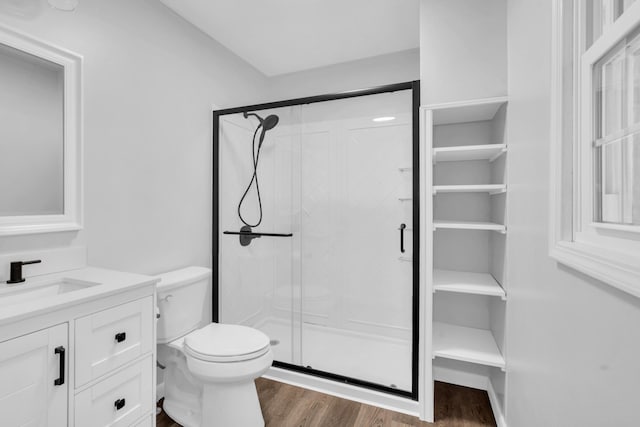 bathroom with vanity, toilet, hardwood / wood-style floors, and a shower with shower door