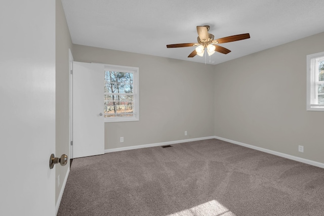 carpeted spare room featuring ceiling fan