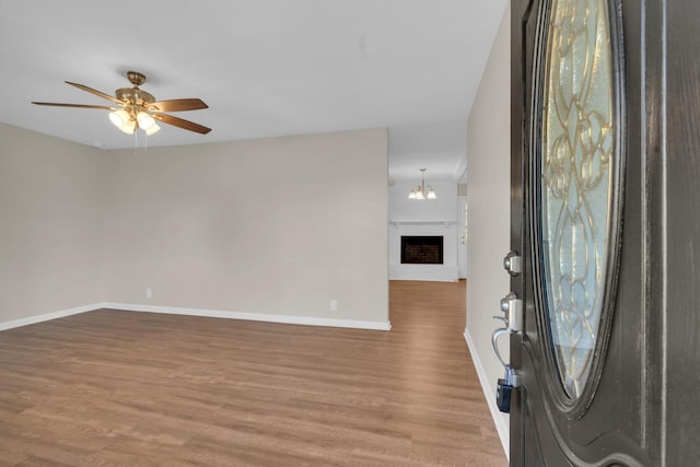 entryway featuring ceiling fan with notable chandelier and light hardwood / wood-style floors