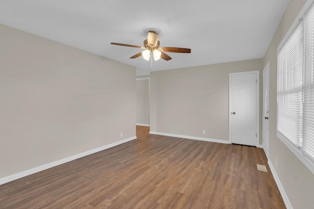 spare room featuring ceiling fan and dark hardwood / wood-style flooring