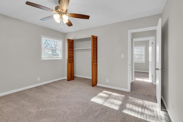 unfurnished bedroom with light colored carpet, a closet, and ceiling fan