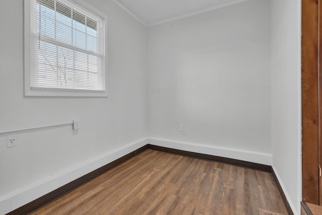 spare room with ornamental molding and dark hardwood / wood-style floors