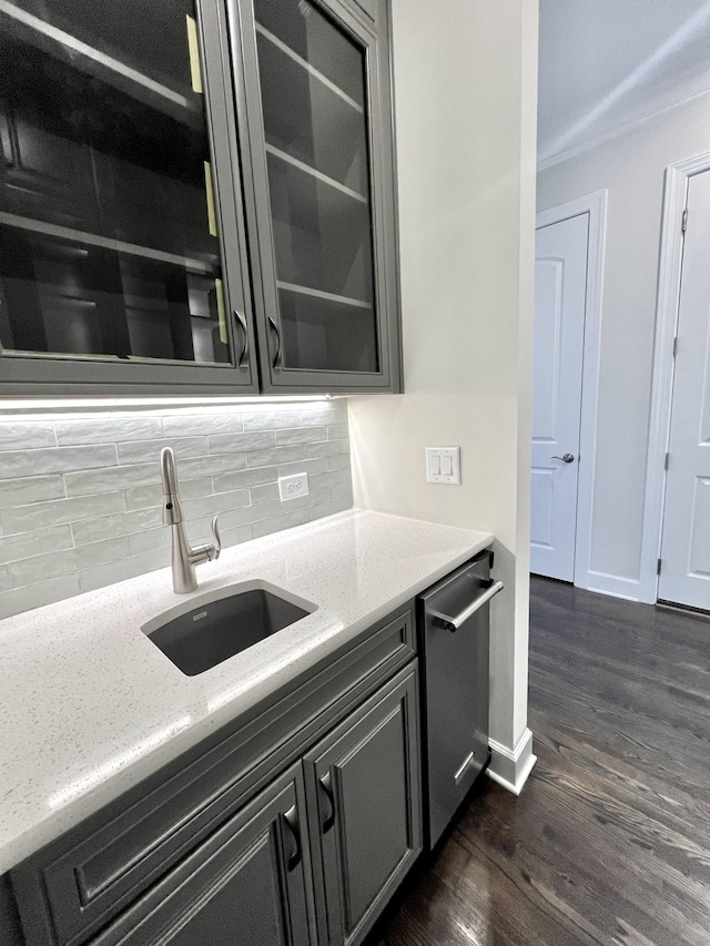 kitchen featuring light stone counters, decorative backsplash, stainless steel dishwasher, and dark hardwood / wood-style floors