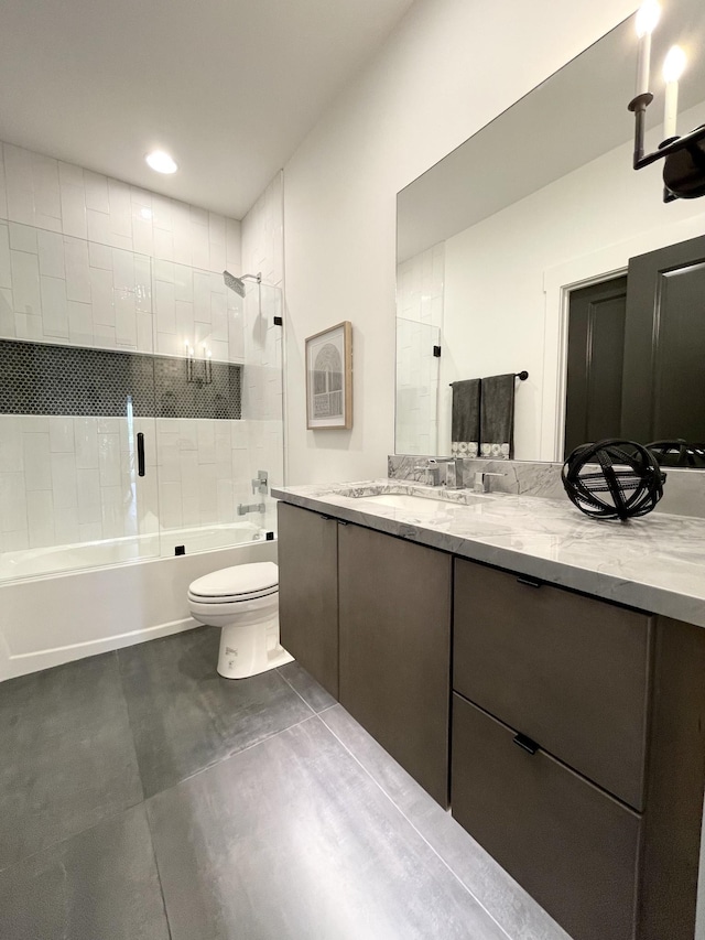 full bathroom with tiled shower / bath, vanity, and toilet