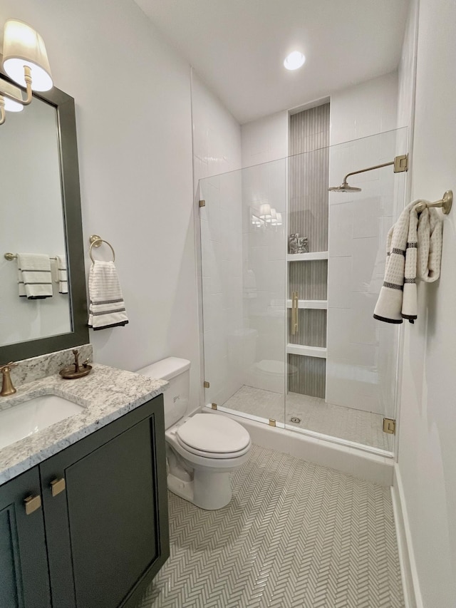 bathroom with tile patterned flooring, vanity, toilet, and walk in shower