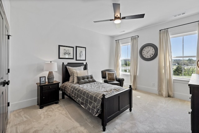 carpeted bedroom with ceiling fan and multiple windows