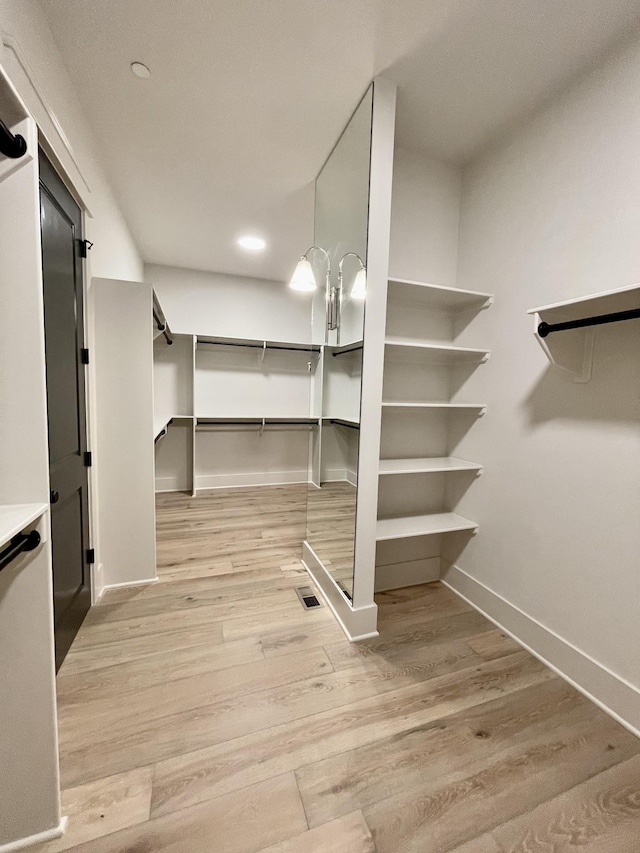 spacious closet with light hardwood / wood-style floors