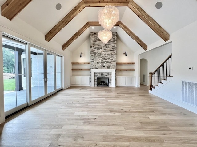 unfurnished living room with an inviting chandelier, high vaulted ceiling, light wood-type flooring, beam ceiling, and a tiled fireplace