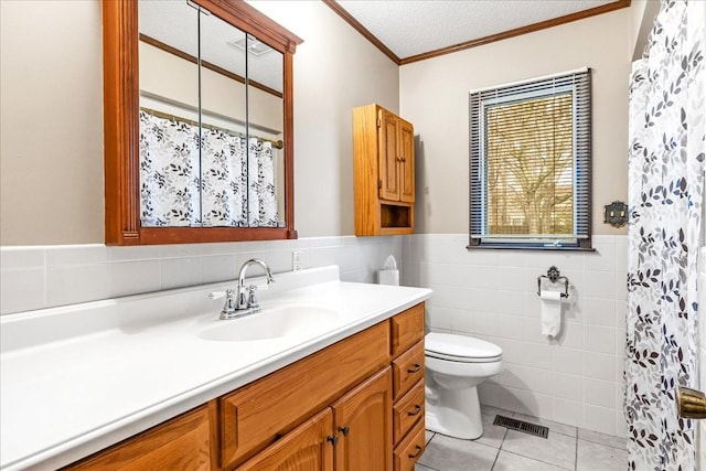 bathroom with tile patterned flooring, vanity, ornamental molding, a textured ceiling, and toilet