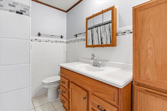 bathroom with tile patterned floors, ornamental molding, vanity, and tile walls