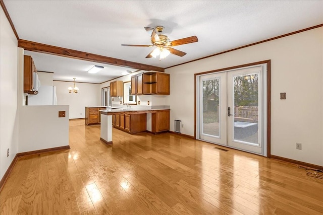 kitchen with crown molding, white fridge, light hardwood / wood-style floors, and hanging light fixtures