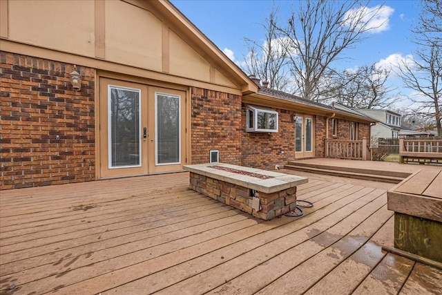 deck with a fire pit and french doors